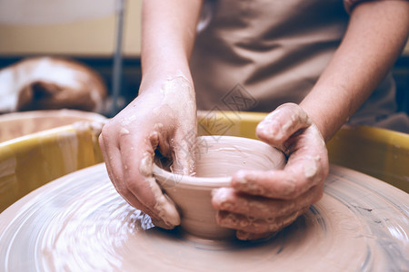 做陶器陶瓷车间女孩在陶瓷炉上做锅轮子背景