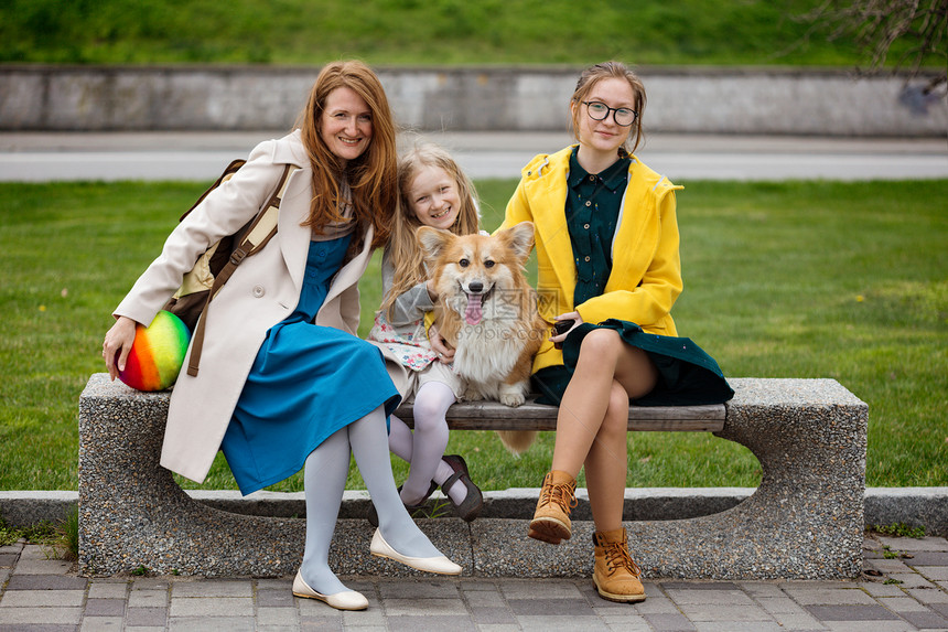 母女三人和狗狗坐在石凳上望着镜头图片