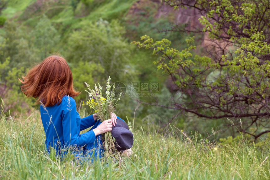 夏天美丽的女孩在草地上带着一束野花图片