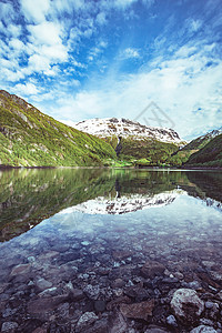 美丽的挪威雪山风景在水中反射图片