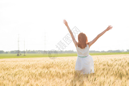 快乐的夏天和自由阳光明媚的下小麦田的美丽女孩图片