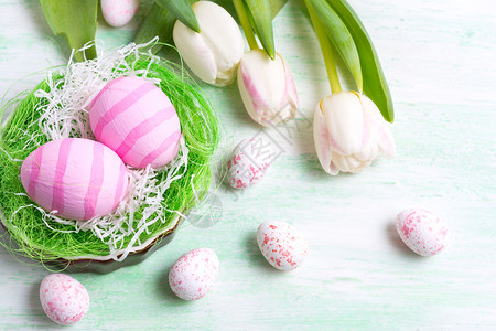 东方快乐的问候背景白色郁金香和粉红条纹彩蛋在巢穴图片