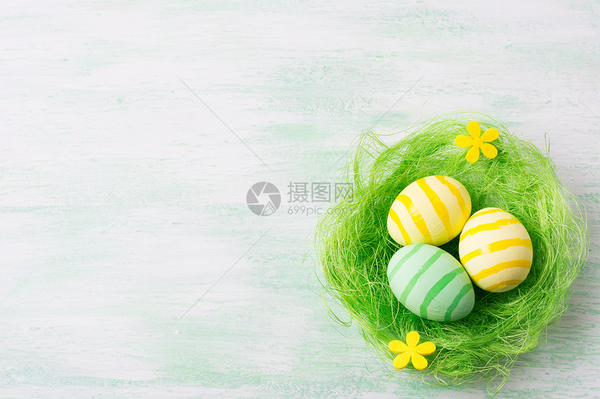 东边快乐的问候背景绿巢复制空间内有条纹彩蛋和黄花图片