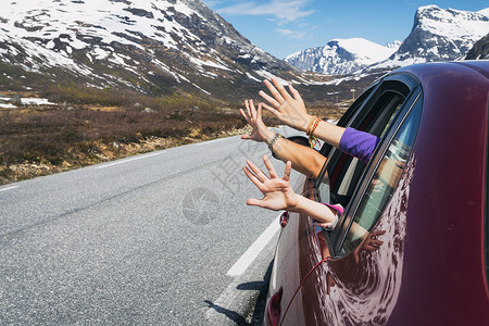 一家三口开车旅行途中把手伸出窗外图片