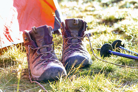 旅游者在山上徒步旅行帐篷靴子和登山柱图片