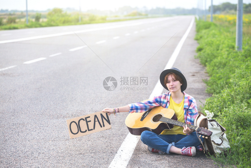 女孩带着吉他沿路搭便车图片