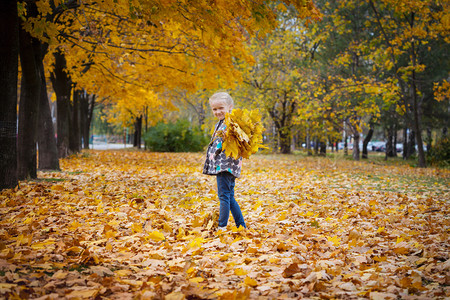 秋天来了小女孩在树林里开心的玩耍图片