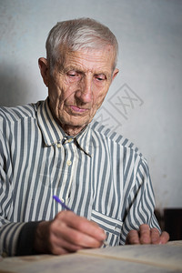 以笔记本写作的老年人肖像图片