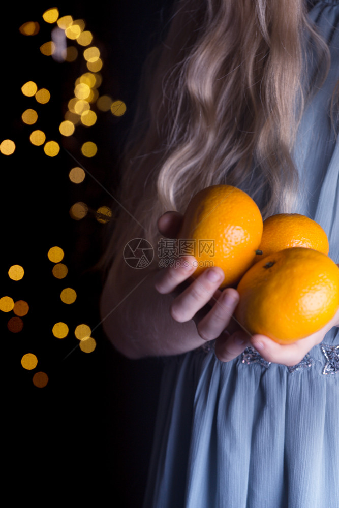女孩手里握着橘子的小女孩图片