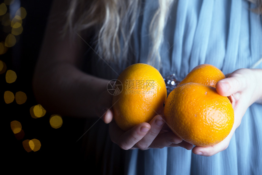 女孩手里握着橘子的小女孩图片