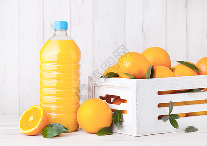 白木箱中含有生橙子的机新鲜汁塑料瓶图片
