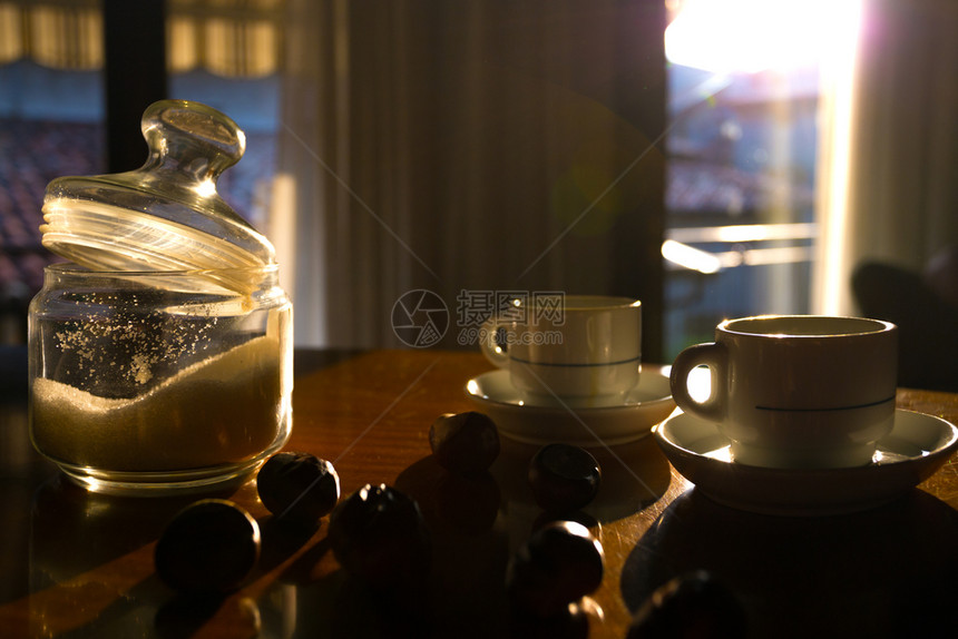 早餐咖啡栗子和窗户的咖啡栗子和窗户后面有太阳图片