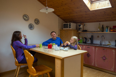 幸福的家庭在厨房桌边喝茶图片
