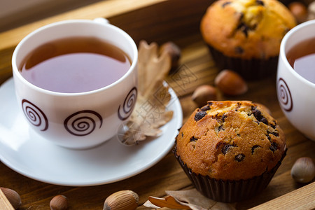 在茶盘上杯子早餐蛋糕和在木盘上喝茶背景