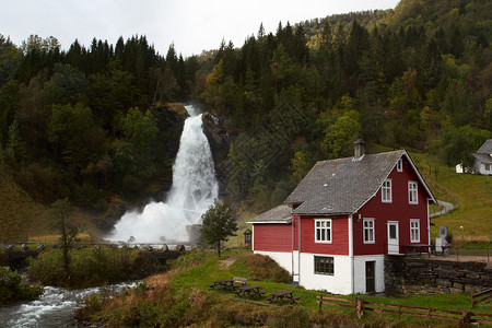 挪威木屋和远处的瀑布图片