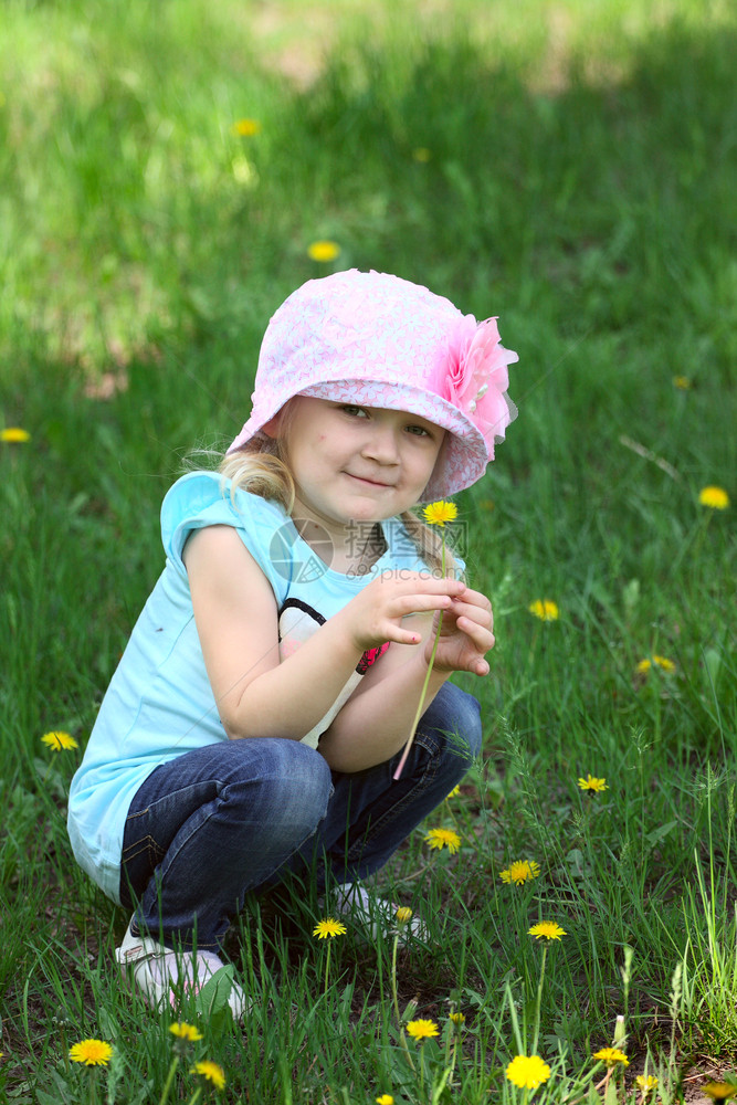 小孩坐在公园的草地上图片
