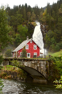 传统的挪威木制房屋远处有瀑布图片