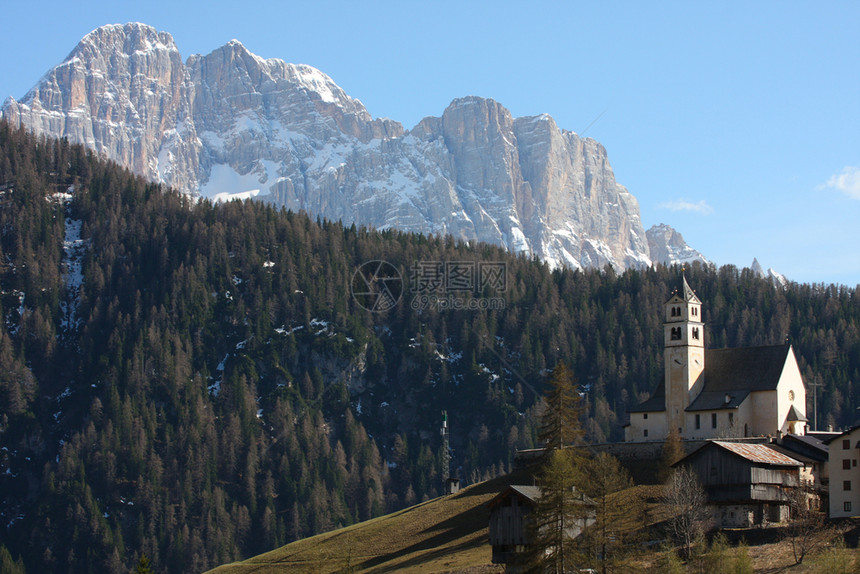 山丘上的教堂雪在背景中意大利图片