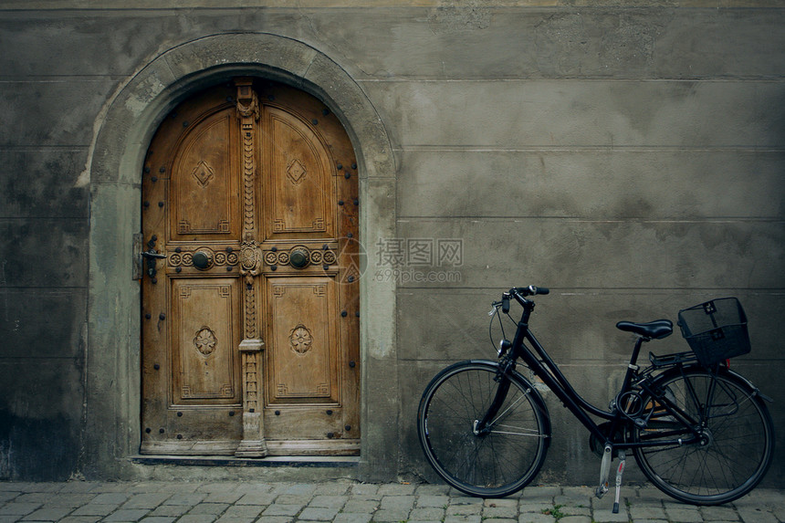 站在旧楼门前的自行车图片