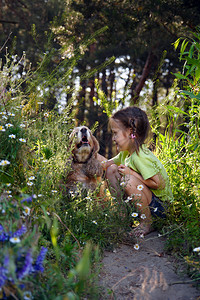 小女孩和狗坐在草地上图片