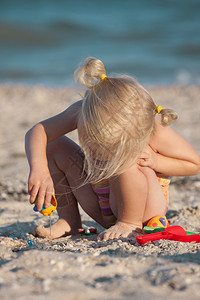 在海滩上玩玩具的小女孩图片