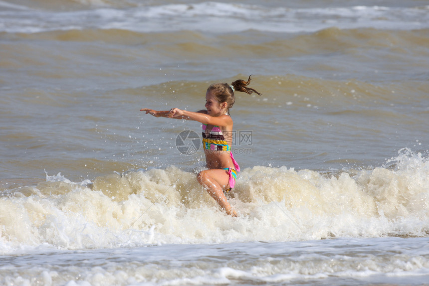笑的小女孩在海里跳跃图片