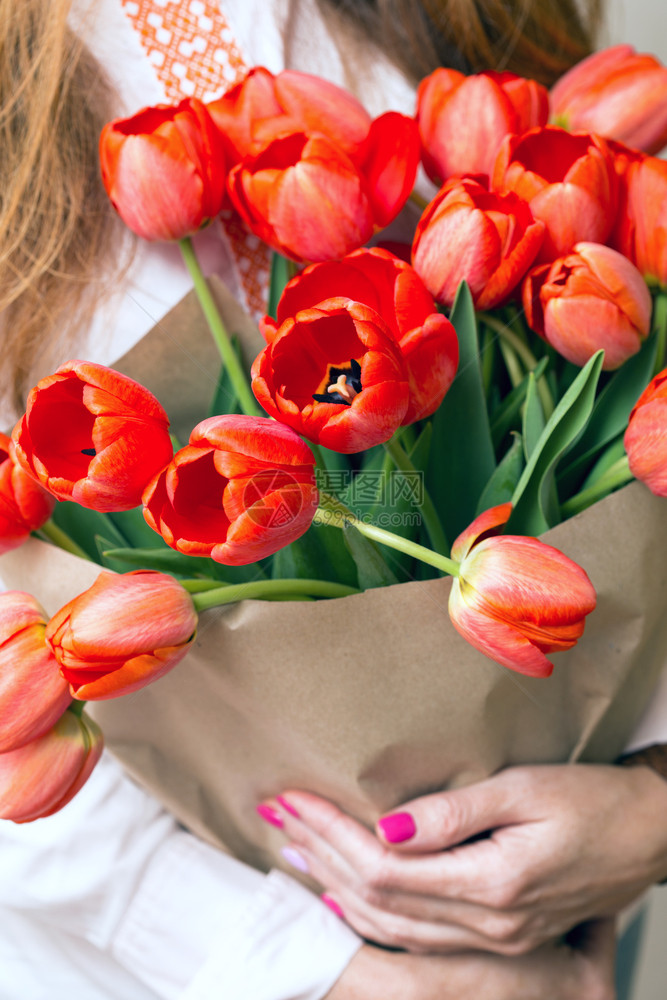 女孩手里握着一束巨大的红郁金香花图片
