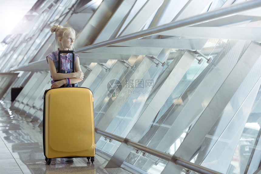拉着手提箱站在机场走廊的女孩图片