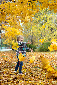 小女孩在公园里玩树叶图片