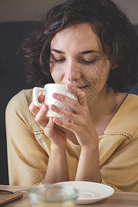 梦幻中的女孩坐在一杯咖啡手握着图片