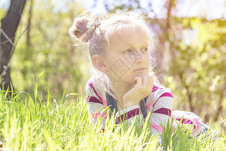夏天美丽的小女孩站在山边草原上图片