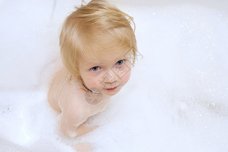 小女孩在洗澡时被肥皂覆盖在浴缸里背景图片