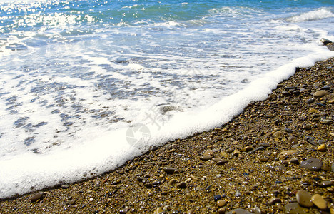 海浪泡沫在冰封的海岸上浪背景图片