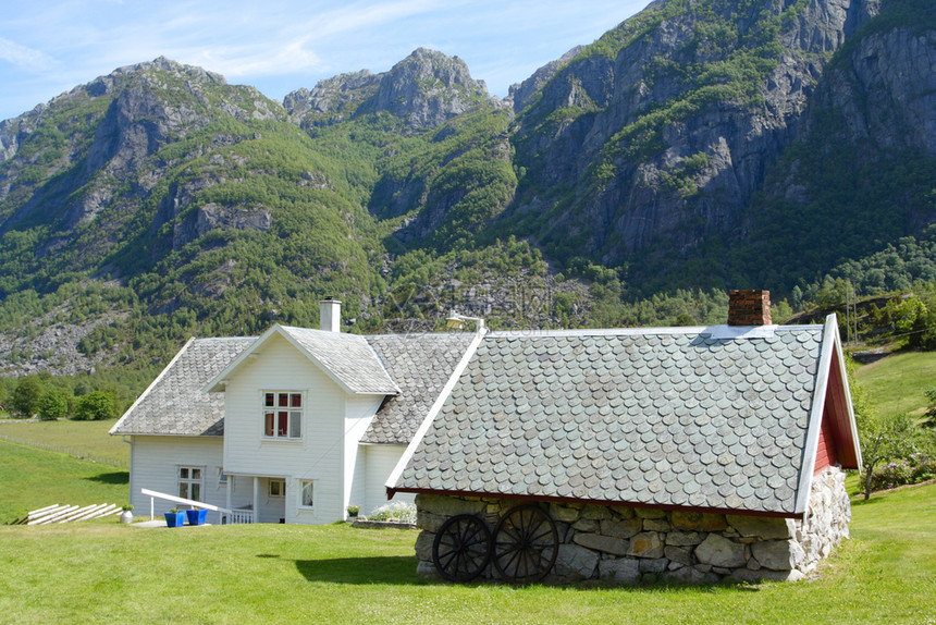 传统挪威木制房屋站在草坪和山丘上图片