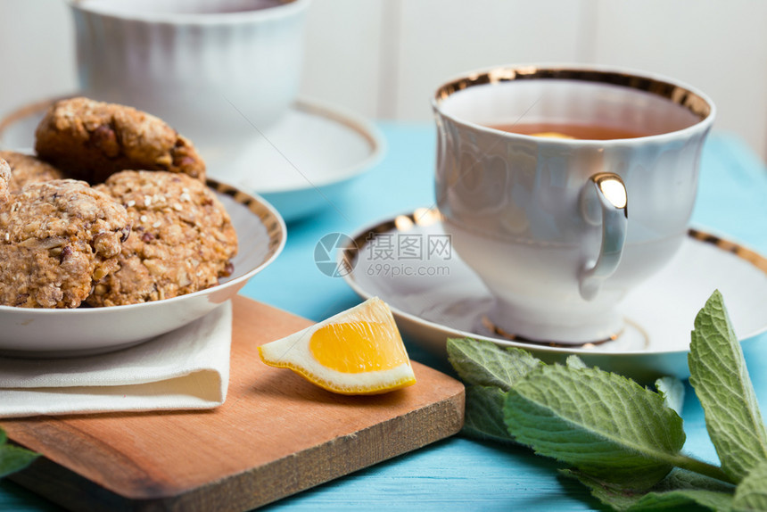 茶会美的装饰桌配有杯子酱汁茶叶和燕麦饼干图片