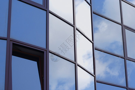 办公室大楼窗户反射的蓝色天空和云彩图片