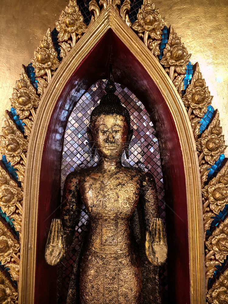 在泰庙的古金老的佛像带有美丽的装饰框架和金墙图片