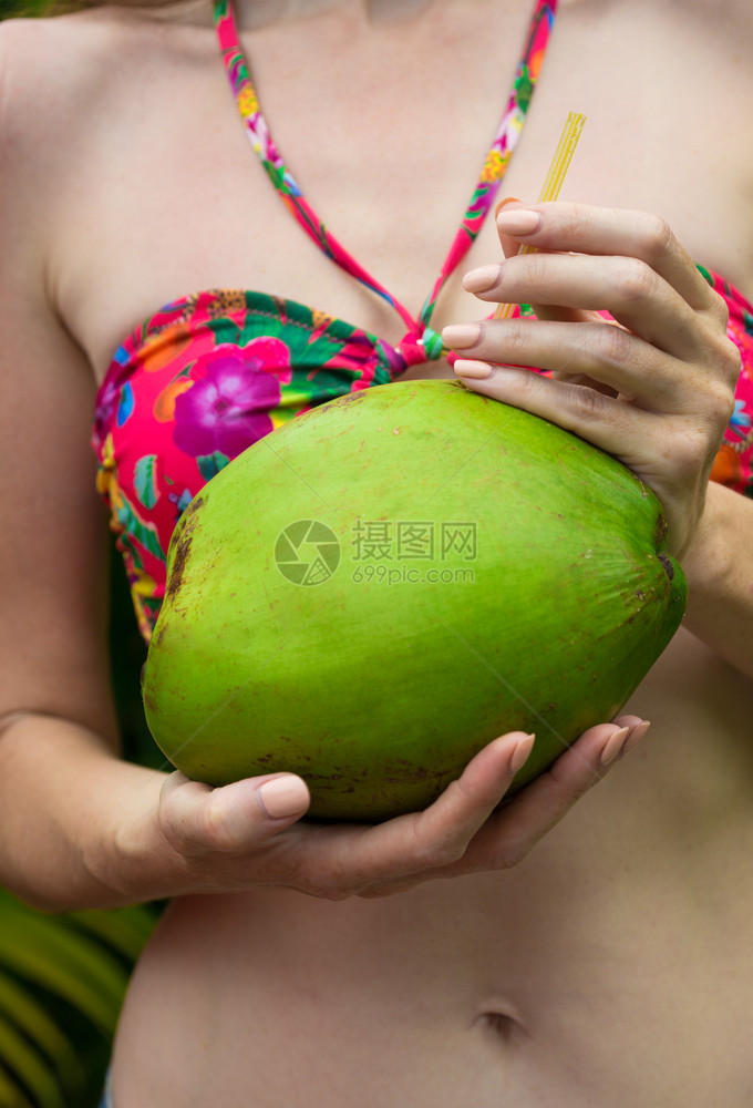 女人手里拿着绿色的椰子靠近了图片