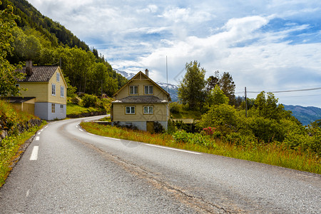 与传统挪威木制房屋并肩穿过的公路Norway图片