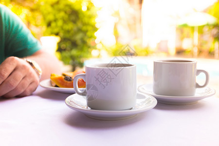 早餐旅行者桌底两杯咖啡卷和木瓜图片