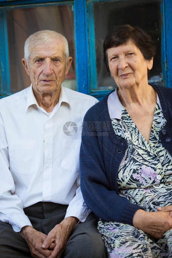 坐在农村住房前面的老年夫妇图片