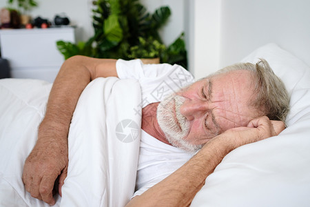 老年男子独睡头痛在房间里床上做恶梦或背景图片