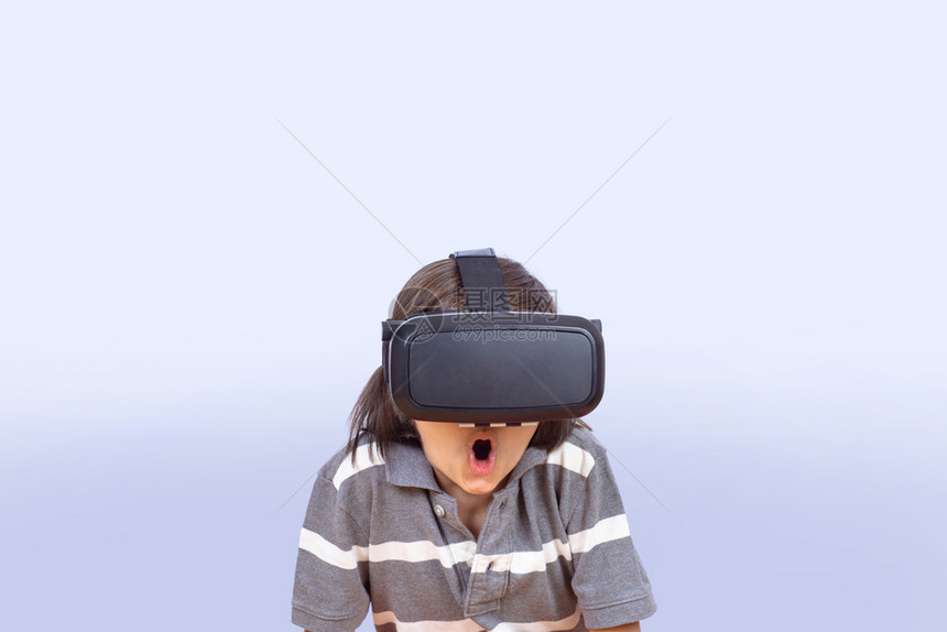 一个小男孩戴vr眼镜和在工作室玩电子游戏的肖像图片