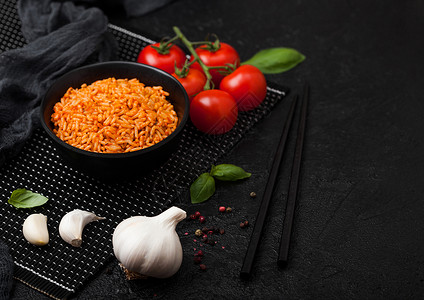 黑盘饭碗番茄烤肉大蒜还有黑底的筷子背景图片