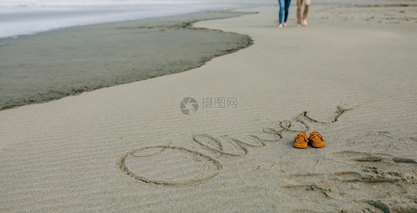 父母散步时孩子的名字奥利弗写在鞋子旁边的沙子上孩子的名字用鞋子写在沙子上图片