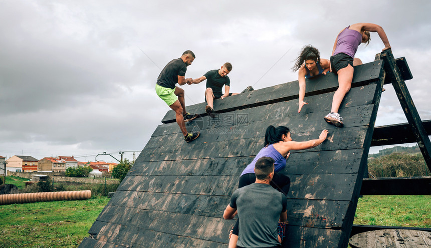 攀登金字塔障碍的障碍课程的一组参与者障碍课程参与者攀爬金字塔障碍图片