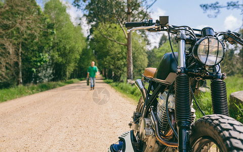 扰频器路边与背景男子用汽油罐走在路边的自家摩托车背景