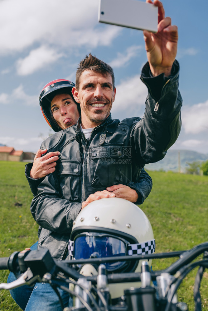 年轻夫妇在摩托车室外自拍夫妇在摩托车上自拍图片