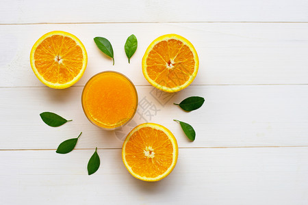 白木本底有新鲜果实的玻璃橙汁图片