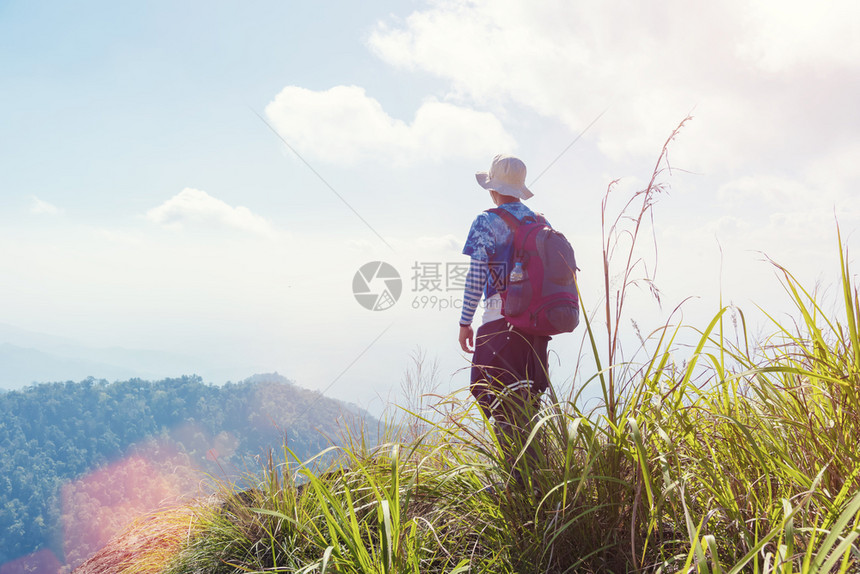 旅行和自由概念背包旅行者站立在山顶仰望阳光照耀有免费复制空间图片添加文字信息设计艺术工作的背景图片